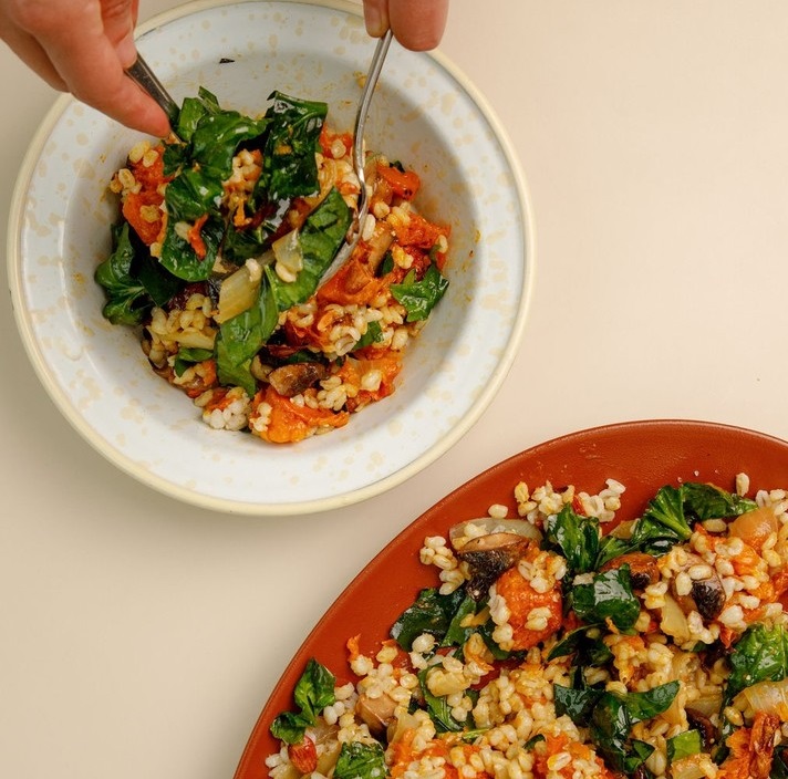 Ensalada de cebada acompañada con espinacas y calabaza